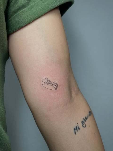 Perrito caliente minimalista y lettering en el brazo