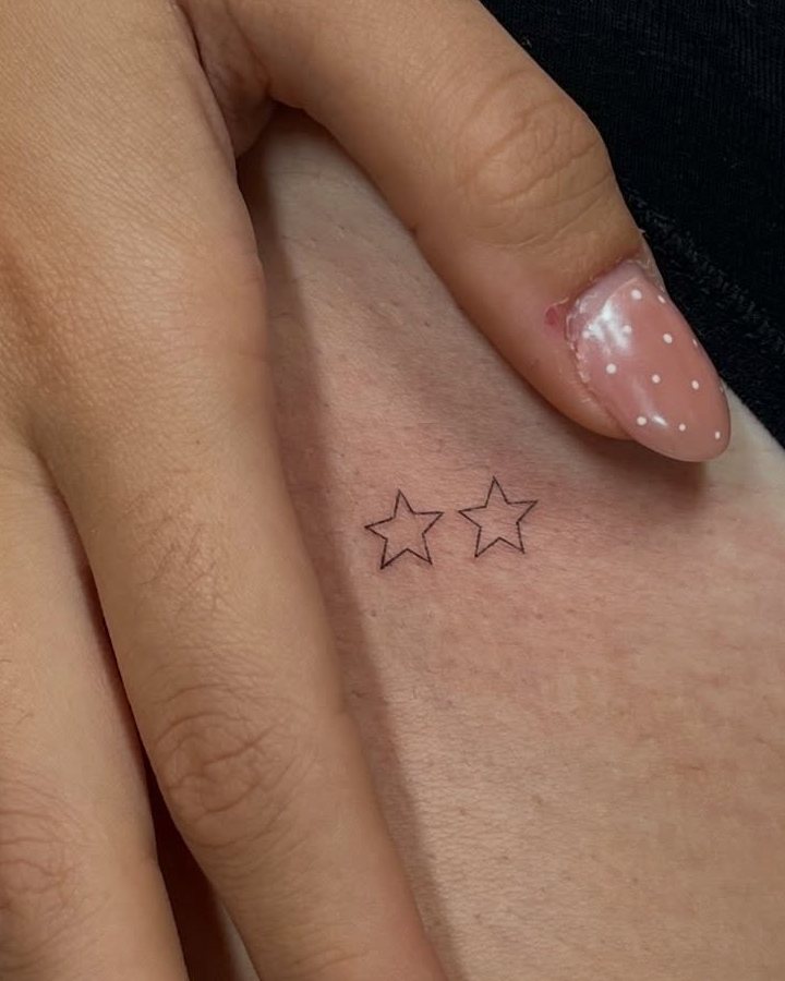 Dos estrellas pequeñas tatuadas en la cadera