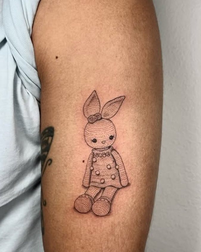 Tatuaje de una coneja de ganchillo en el brazo