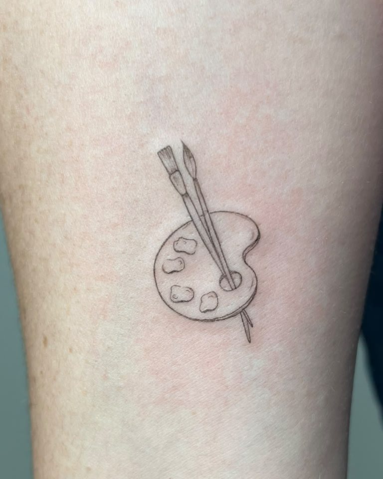 Paleta de pintor con pinceles en el antebrazo
