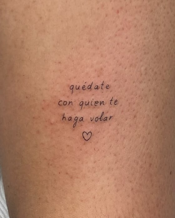 Frase «quédate con quien te haga volar» y un corazón, en letra pequeña