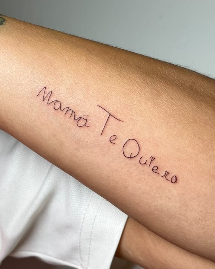 Frase «Mamá Te Quiero» en letra manuscrita en el antebrazo